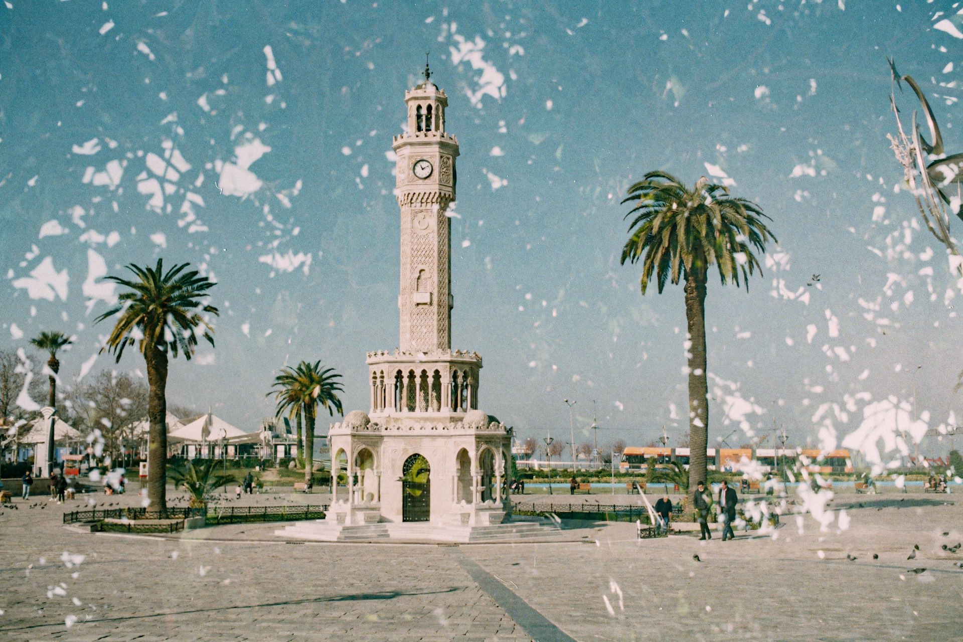 a white clock tower sitting in the middle of a park